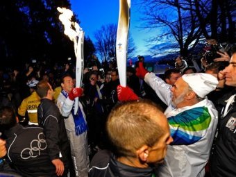 Губернатор Калифорнии Арнольд Шварценеггер с олимпийским факелом. Фото (c)AFP